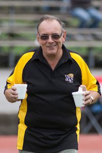 Robbie smiling and carrying 2 coffees